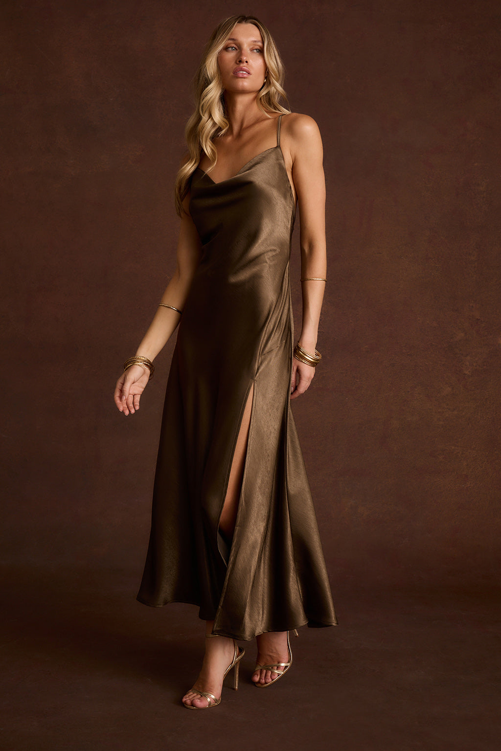 Olive satin cowl neck slip dress with thin straps and a front thigh slit.