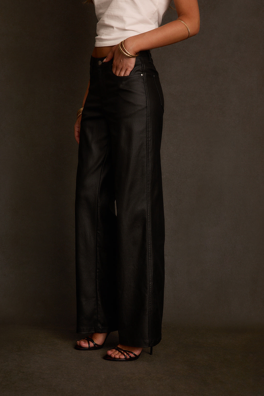 Women's pants side angle showing straight leg silhouette and coated finish