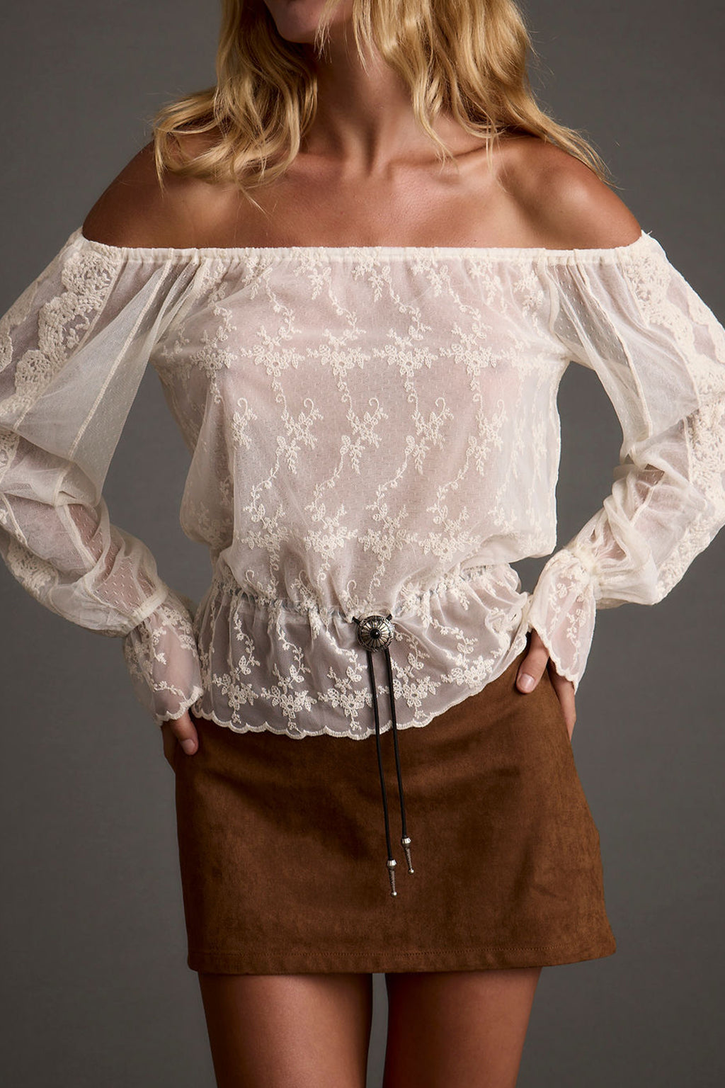 Lifestyle shot of the ivory top styled for day-to-night versatility.