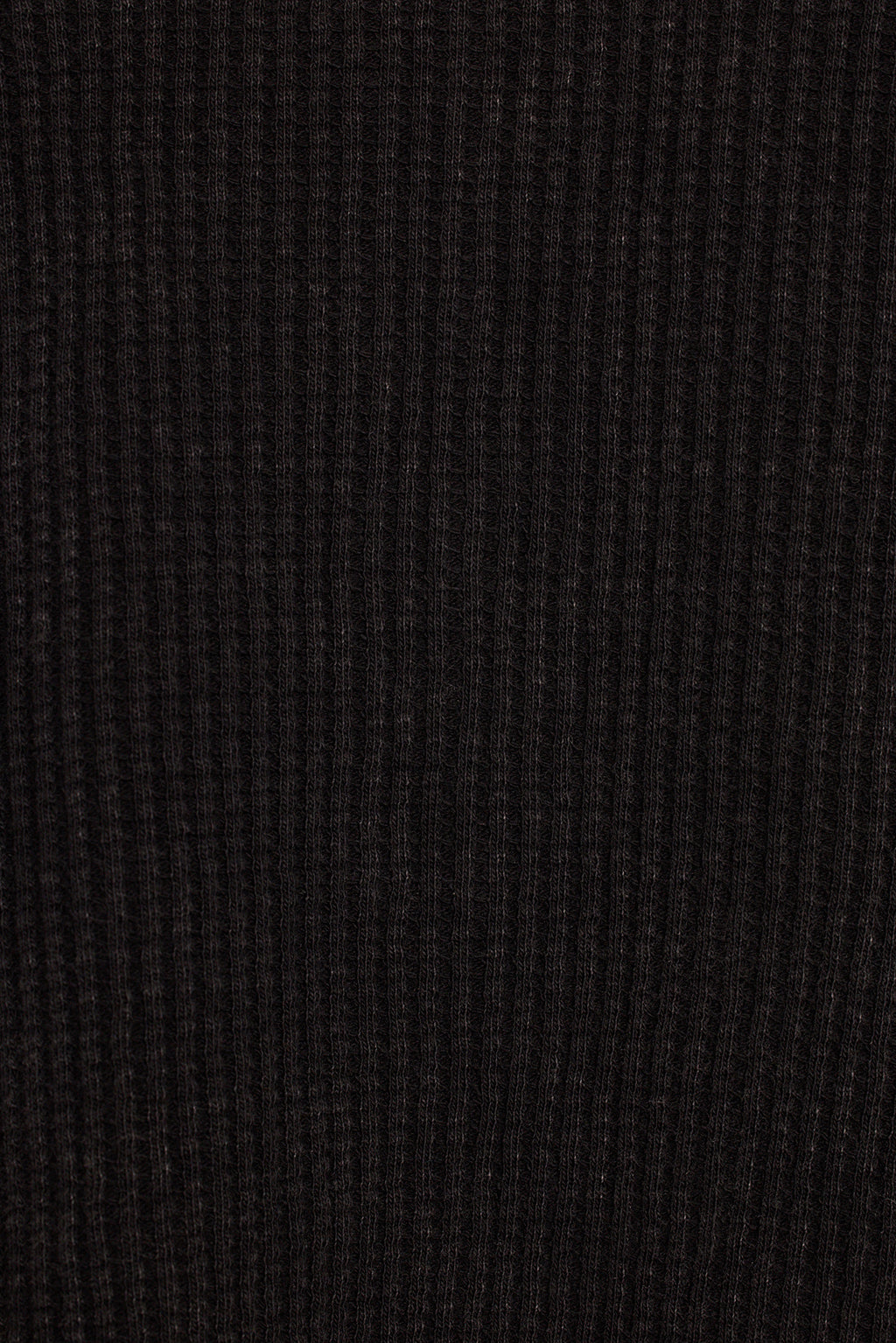 Waffle knit top close-up of button placket, thermal texture, and washed black color