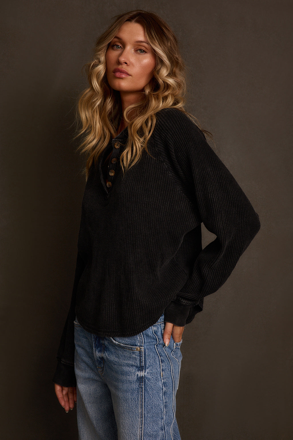 Long sleeve top styled outdoors with olive flannel tied at waist and denim
