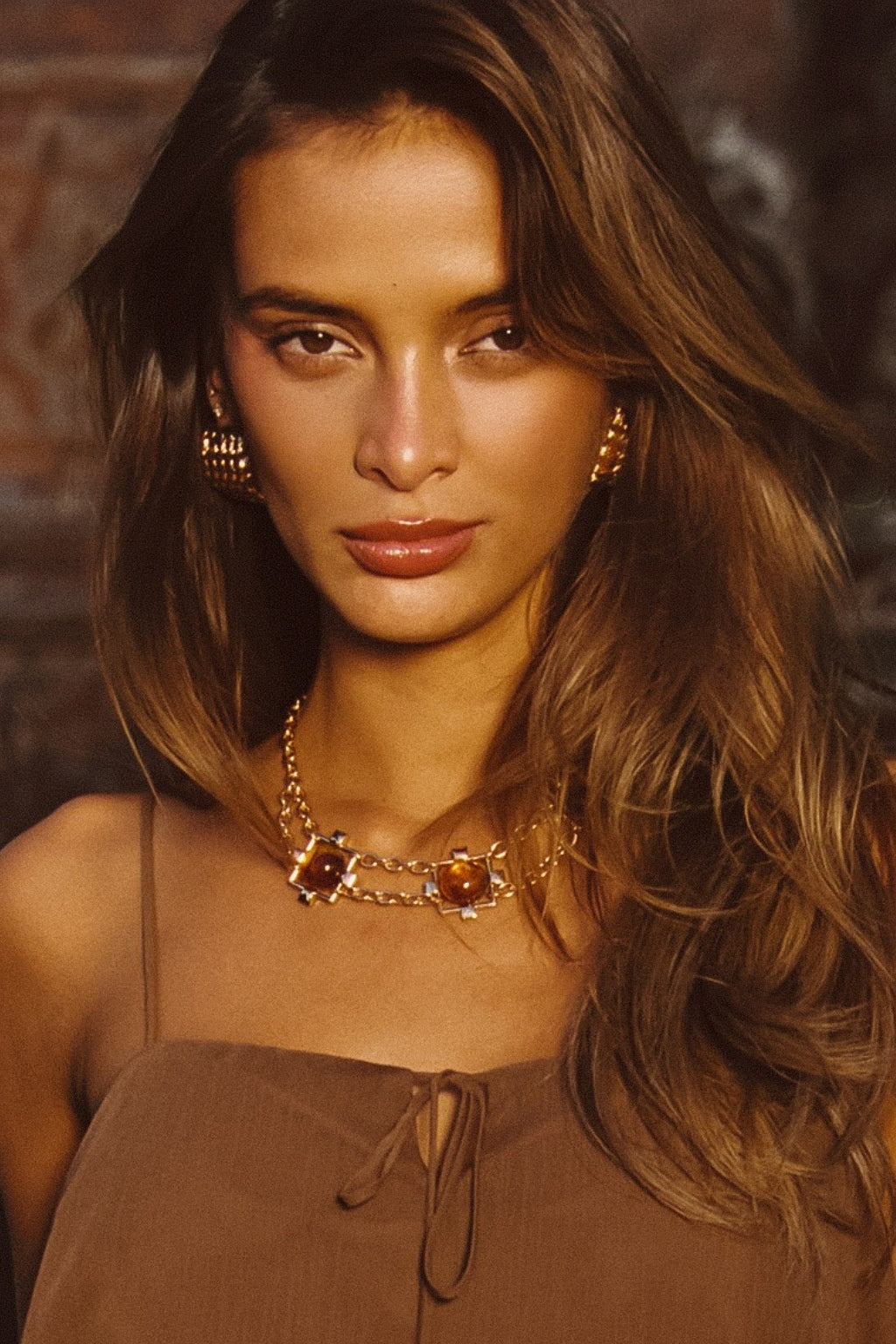 Model wearing the 12th Tribe Coralli Amber Stone Choker, featuring bold amber stone accents, styled with the Costella Mocha Asymmetrical Top and Calaia Gold Earrings.