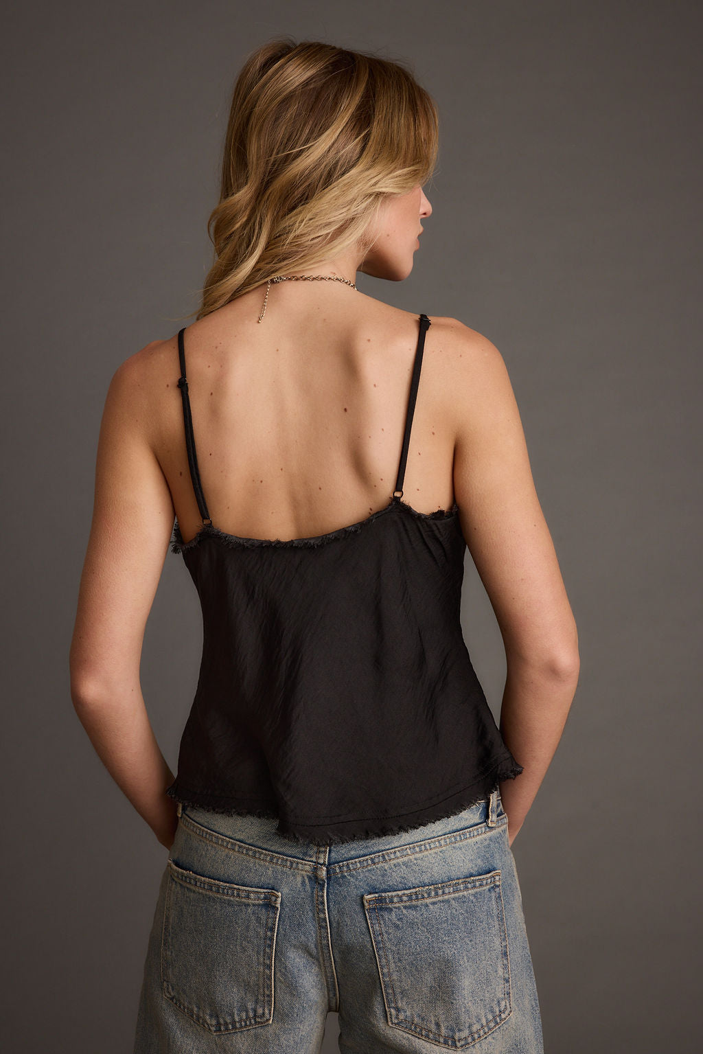 Back view of the black satin piece showing the silhouette and fit.