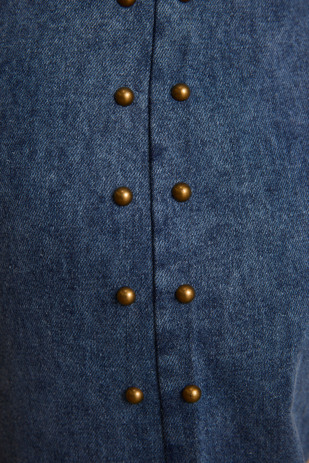 Blue denim chaps with a double row of bronze dome studs down the center front seam