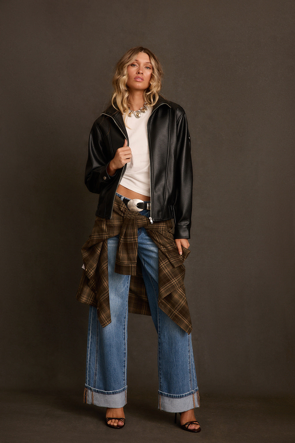Vegan leather jacket outdoor brownstone shot, layered over mesh top with gold jewelry