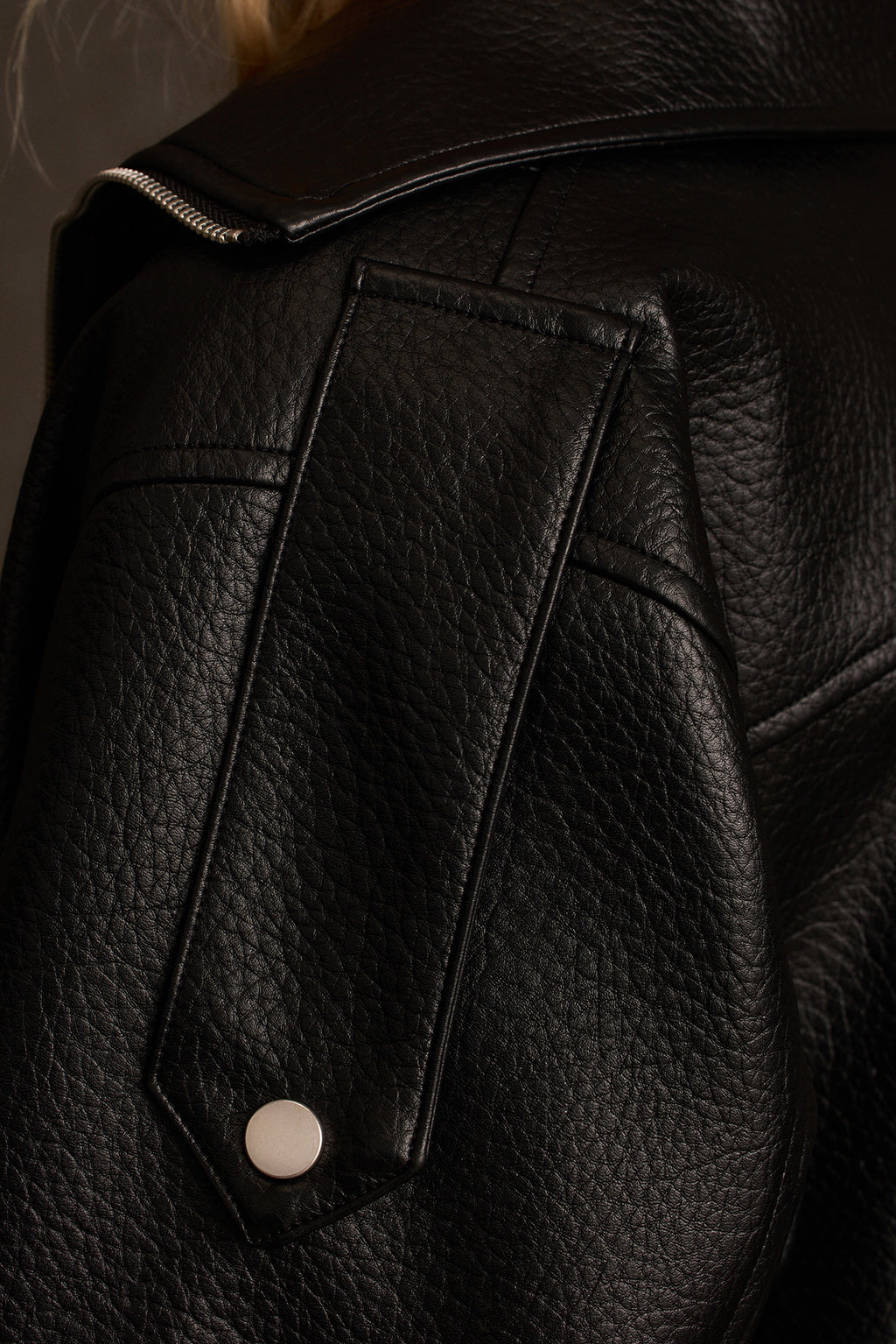 Black jacket full body outdoor shot styled with cuffed denim and pointed boots