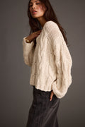 Ivory knit sweater with knit accents, a cable knit sweater dress essential.