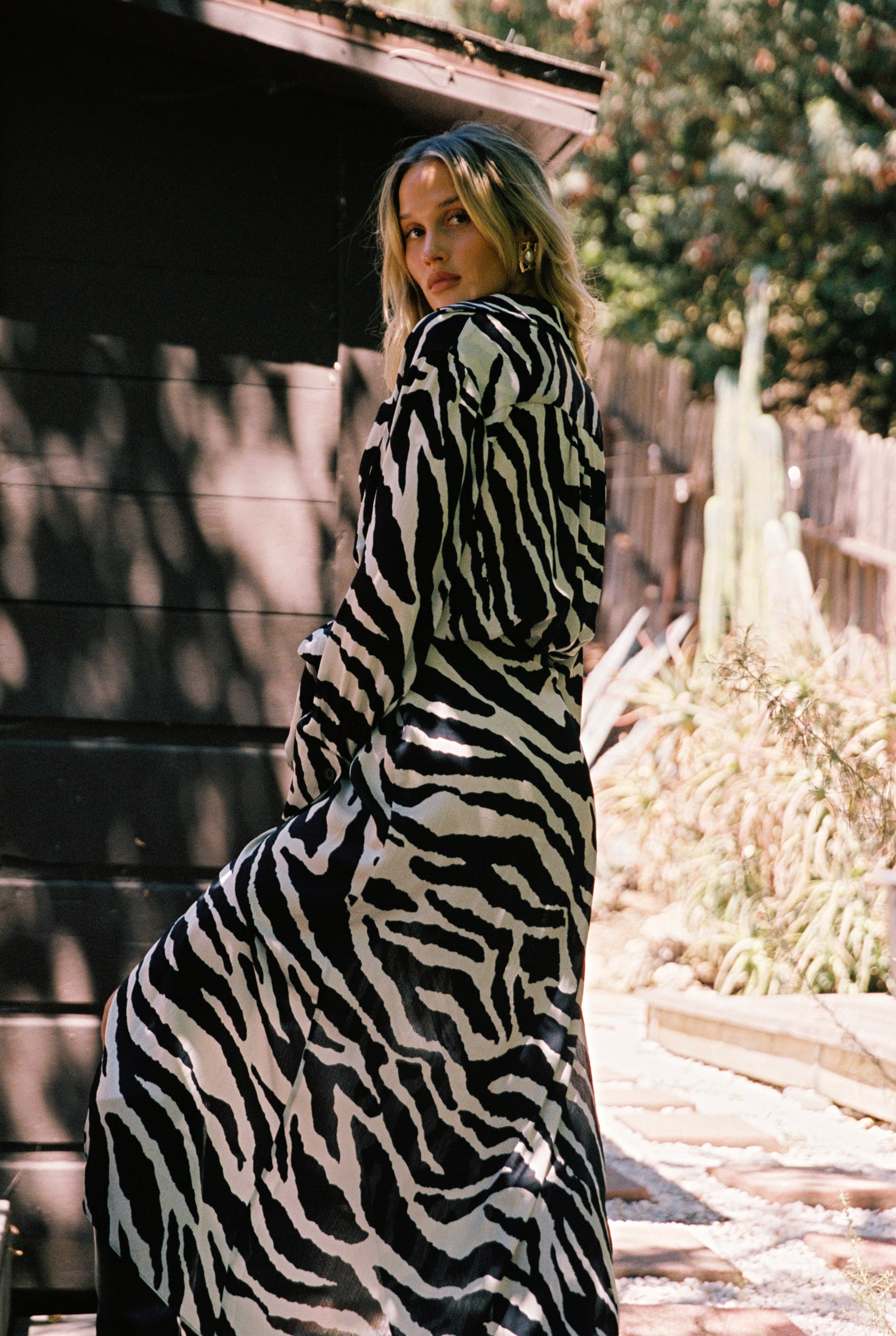 Full-length view of the zebra print midi dress showing the drape and movement.