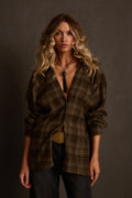 Plaid flannel in olive with oversized fit, worn open with tassel pendant and leather pants