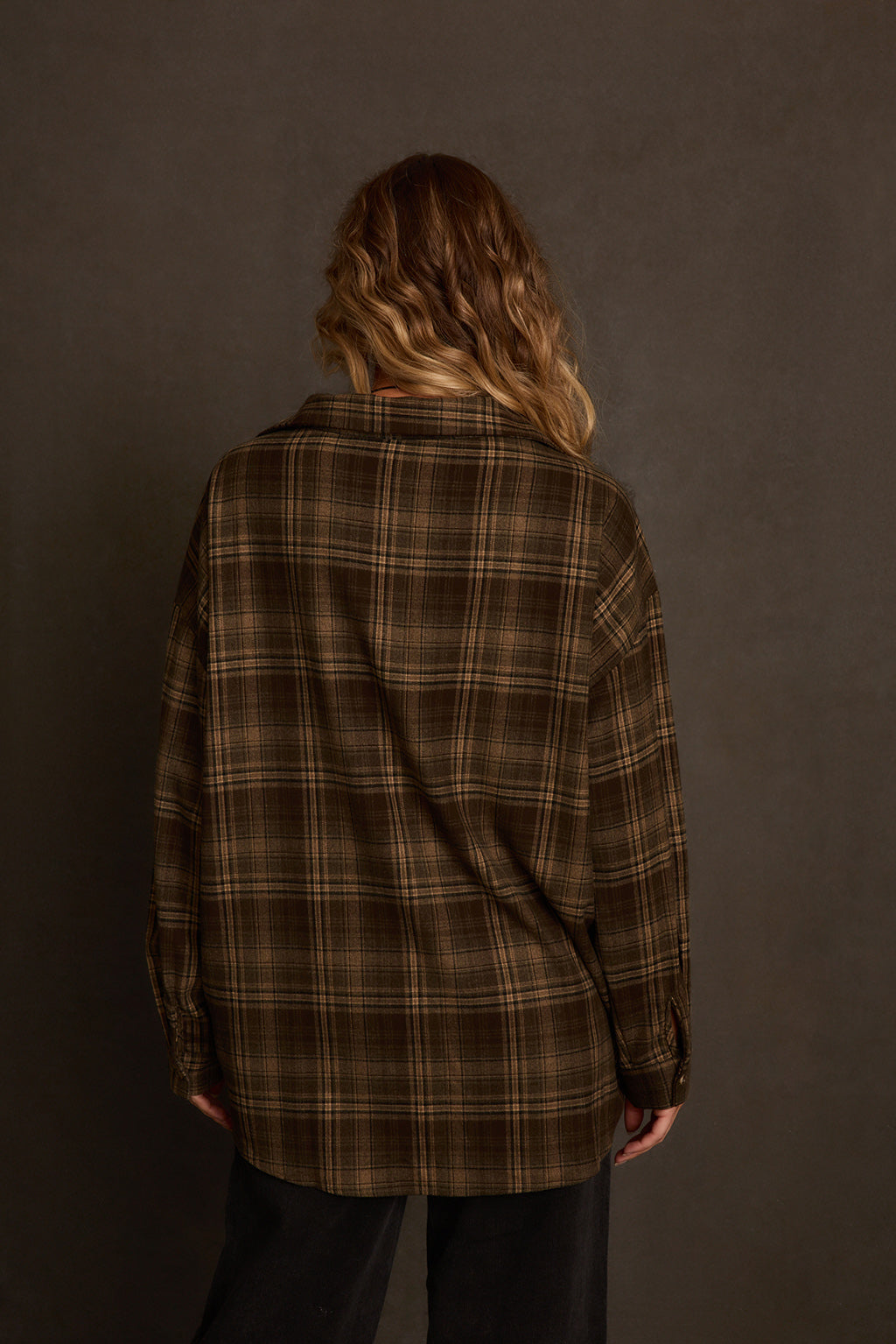 Women's flannel side angle showing relaxed oversized fit and rolled cuff sleeves