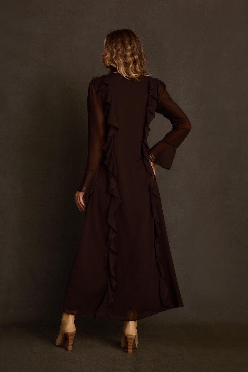 Maxi dress styled with cognac studded belt, cream boots, and gold bangle stack