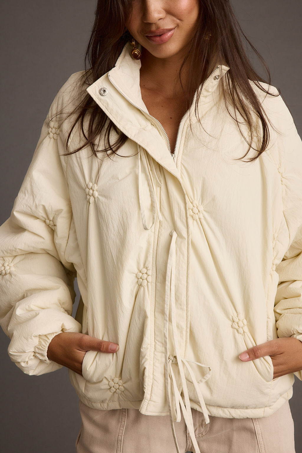 Back view of the cream jacket showing the silhouette and fit.