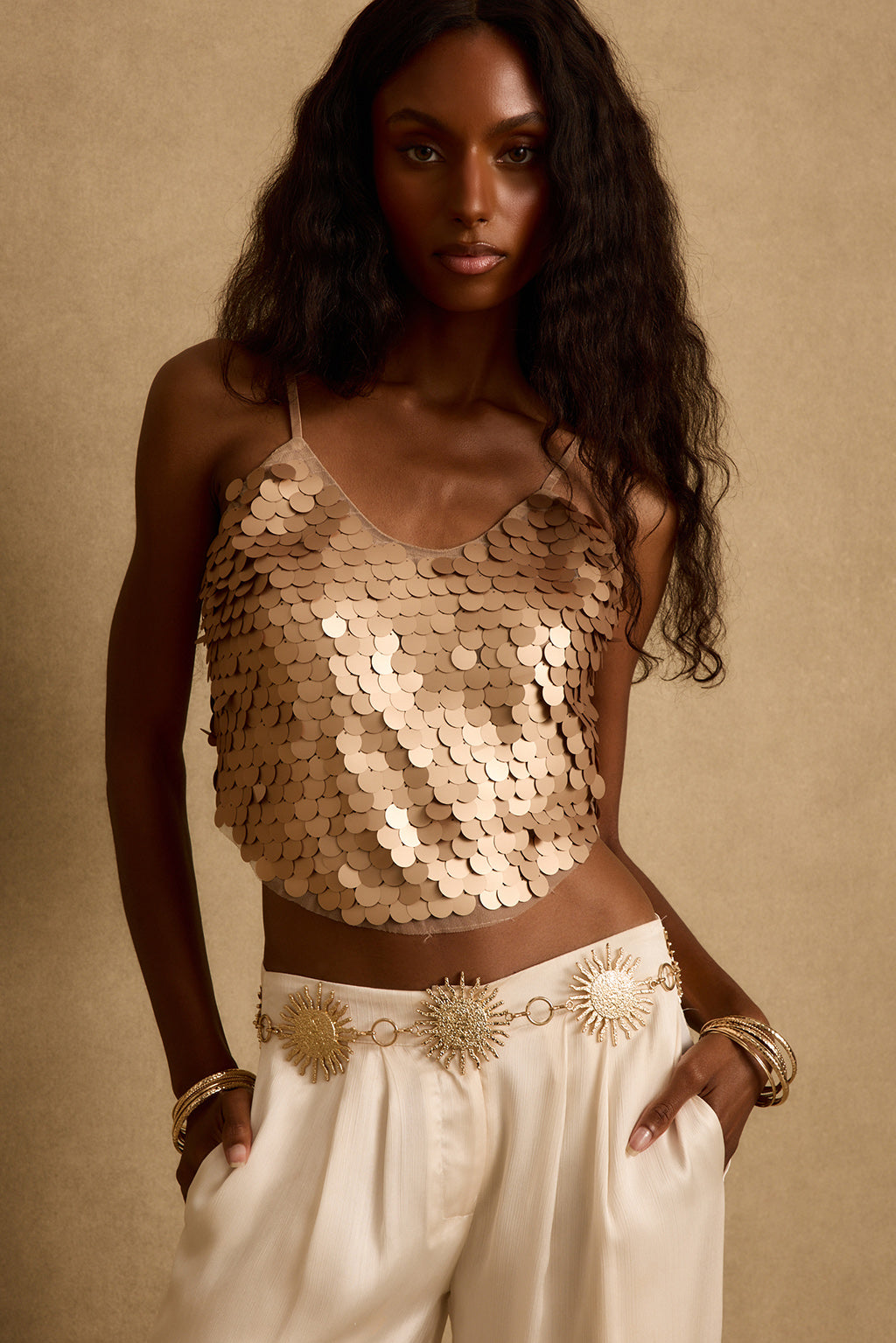 Rose gold payette sequin tank styled with ivory trousers and a sunburst chain belt.