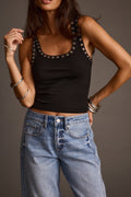 Women's black grommet tank top styled with light-wash wide-leg jeans, front view