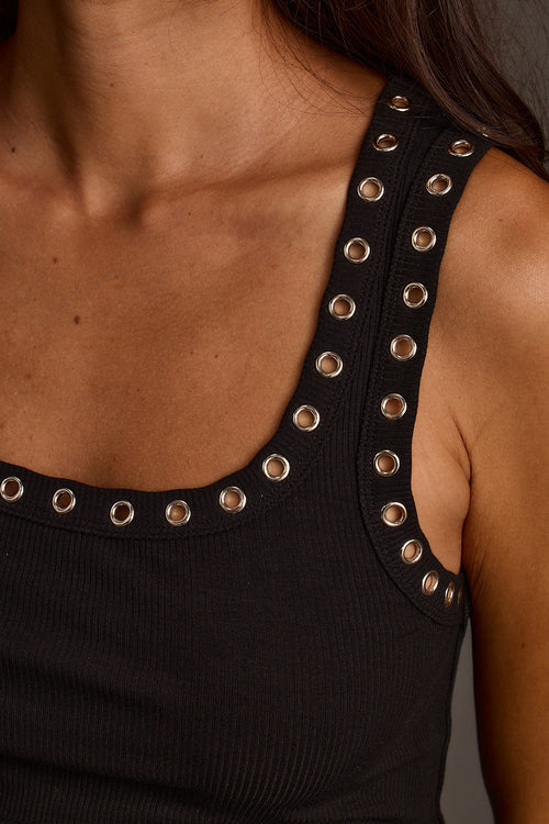 Close-up of women's black grommet tank top with ribbed knit fabric and scoop neckline