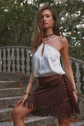 Espresso brown satin fringe sarong skirt styled with white cami on garden steps.