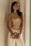 Seaton rose gold payette tank styled on-model with cream wide-leg pants and gold bangles.