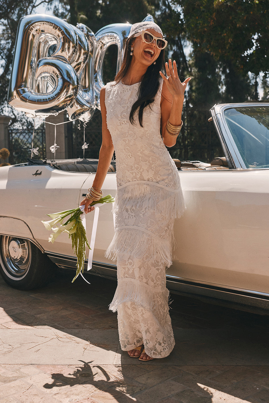 White lace sleeveless maxi dress with tiered fringe detailing along a fitted silhouette.