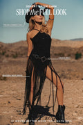 Woman modeling "Desert After Dark" outfit wearing Talon cowboy hat, black sparkly Wisteria maxi fringe dress with Calico belt styling in desert landscape.