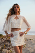 Model wearing the 12th Tribe Isadora Pearl Embellished Cape in soft ivory, featuring delicate pearl embellishments and a sheer draped silhouette, style over the heaven sent Esme set for weddings, bachelorette parties, and vacations.