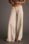Beige low-rise, wide-leg jeans with refined detailing and a flattering silhouette.