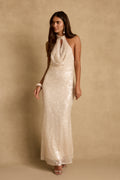 Model wearing the 12th Tribe Noella Champagne Sequin Maxi Dress in a soft champagne, featuring an all-over sequin embellishment and a flowing maxi silhouette,. Style with heels for bachelorette parties, galas, and vacatino events.