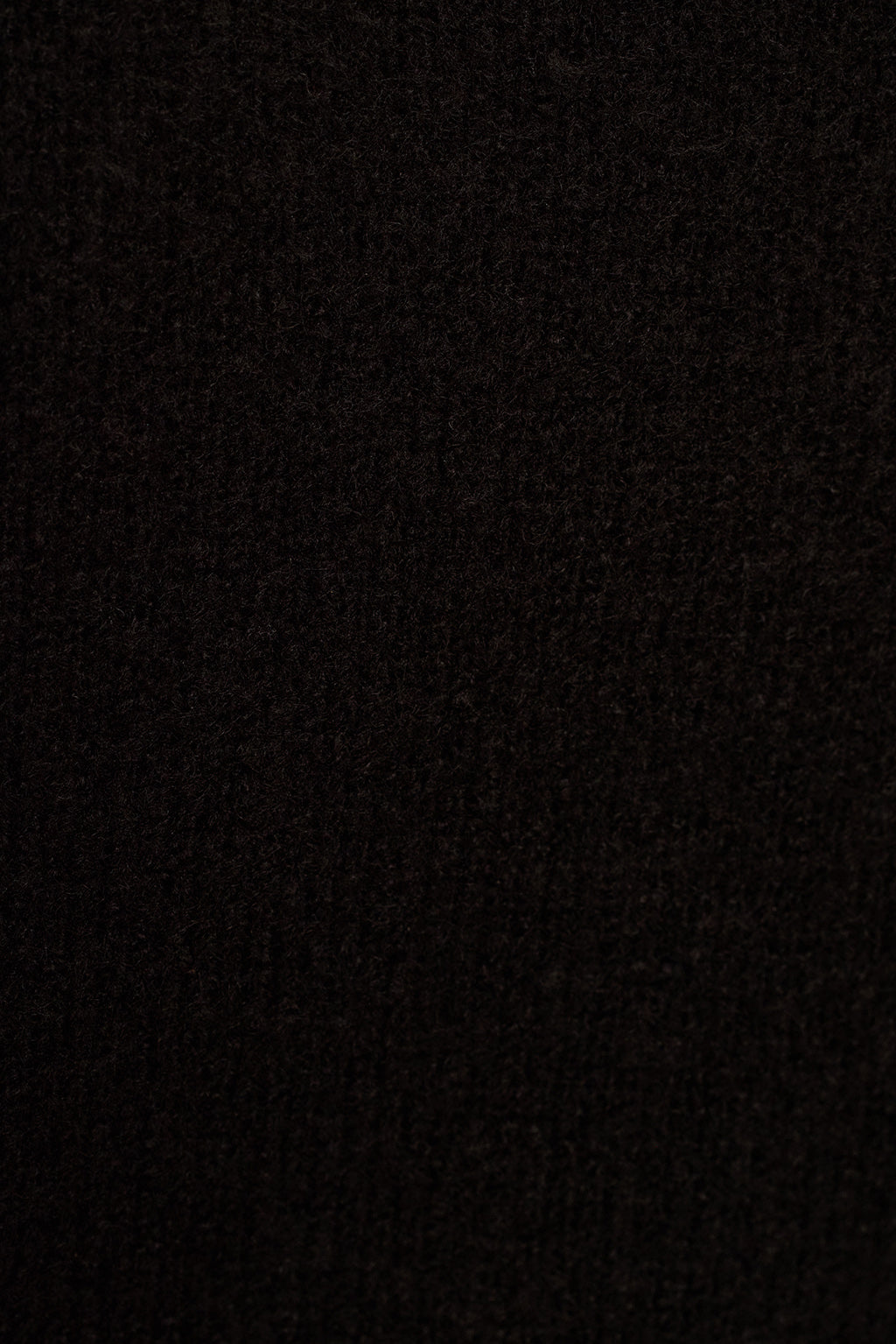 Black knit surplice sweater close-up of wrap V neckline and soft fabric texture
