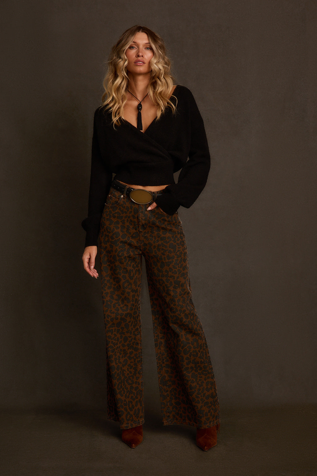 Black sweater back view on model showing smooth knit and cropped hemline