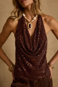 Espresso sequin halter top with draped cowl neckline, styled with gold statement necklace and bangles.