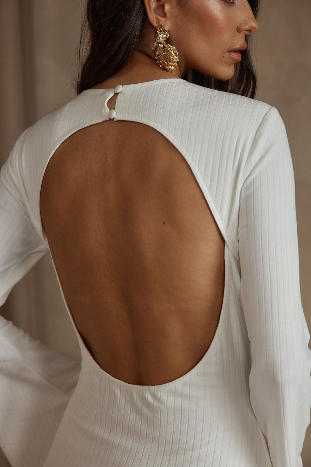 Lifestyle shot of the white dress styled for day-to-night versatility.