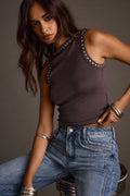 Woman wearing a gunmetal studded tank top with blue jeans and stacked bangles