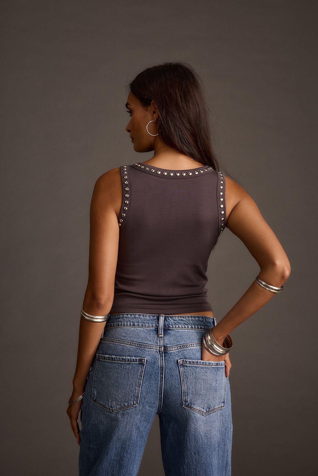 Back view of a gunmetal studded tank top with silver stud detailing along the neckline