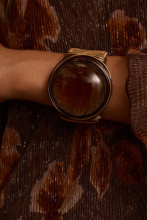 Statement cuff in gold wire wrapping with amber stone, styled with printed velvet dress