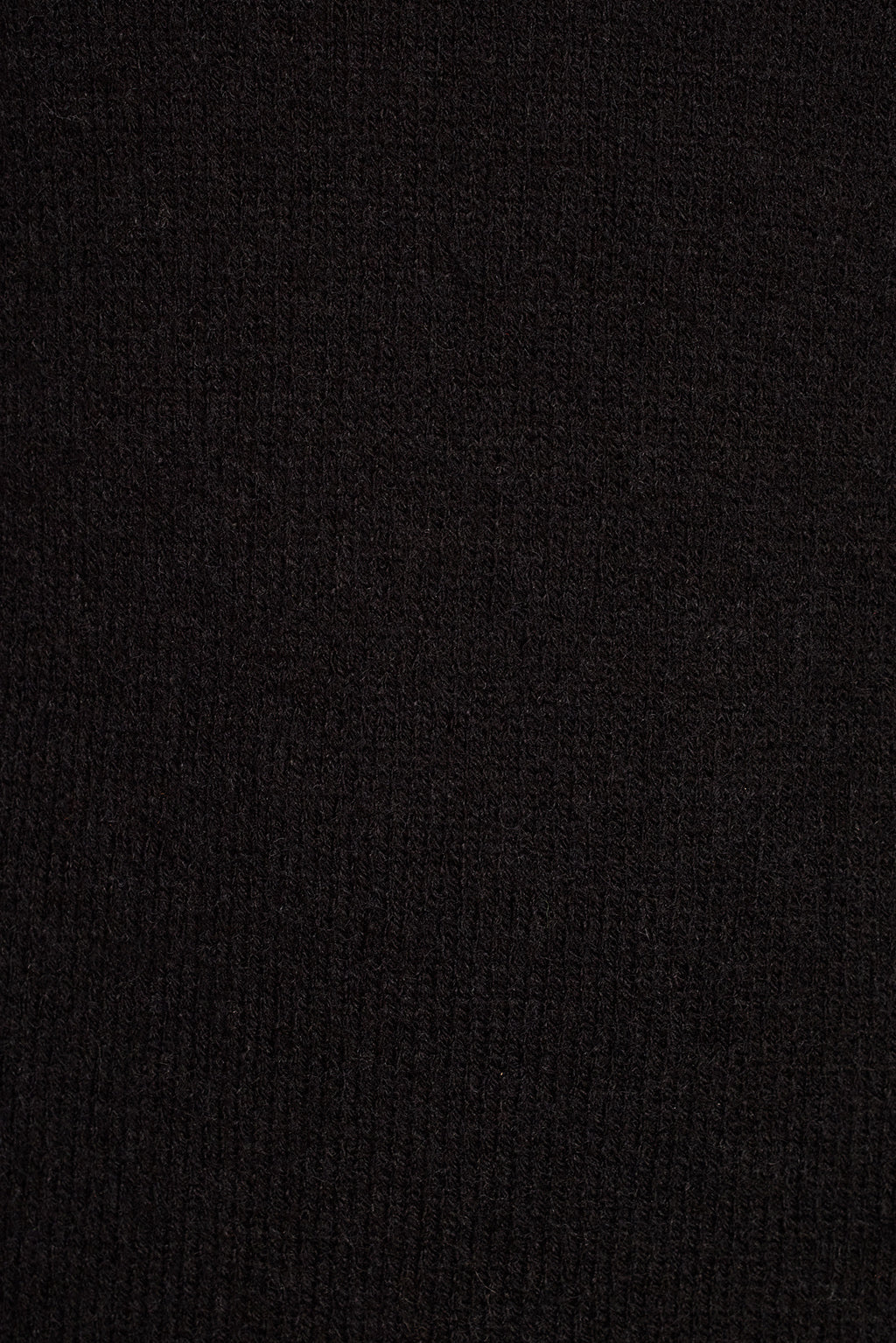 Black knit dress fabric detail close-up showing soft sweater texture and bell sleeve hem
