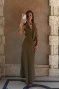 Model wearing the 12th Tribe Zela Olive Cowl Maxi Dress, a vacay-ready flowy satin maxi dress featuring a dramatic front cowl, deep low back, and halter silhouette. Perfect for maxi dresses for beach vacations, Caribbean vacation looks, and warm summer nights out on the town.
