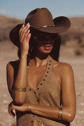 Thatcher Camel Suede Studded Top and Posie Ivory Floral Micro Shorts styled with the Dune Coin Statement Belt, brown cowboy hat, aviator sunglasses, and stacked gold bangles in the desert.