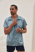 Blue satin shirt with refined detailing and a flattering silhouette.