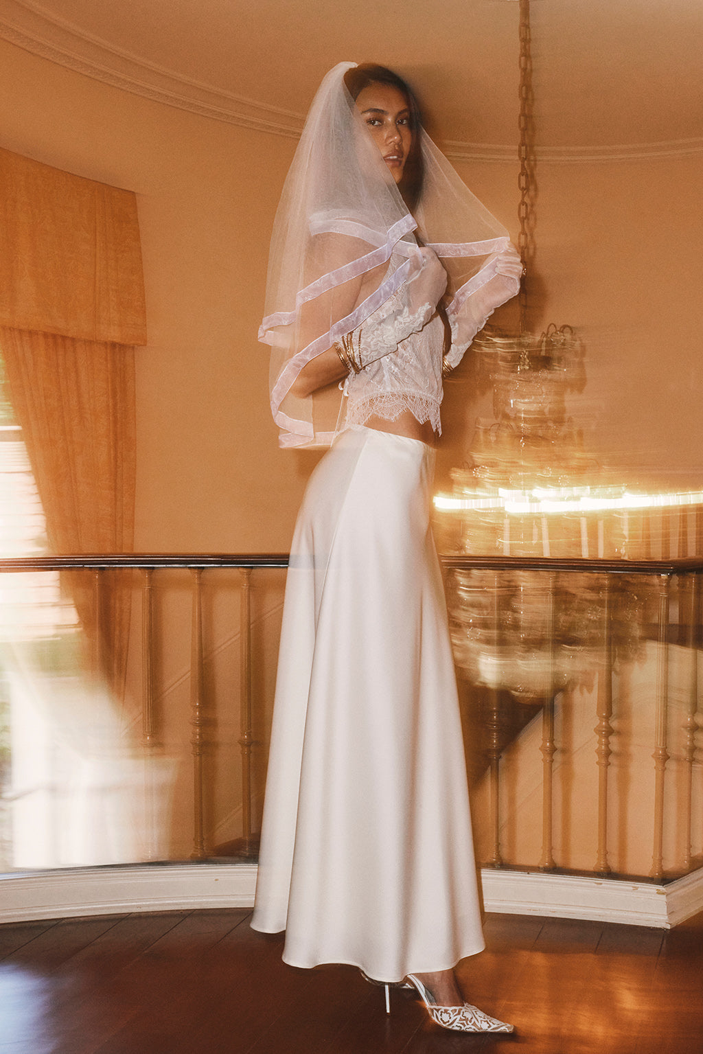 Ivory satin maxi skirt with a flared hem, styled with a lace crop top.