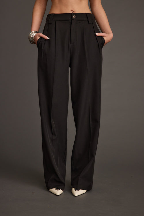 Back view of the black trousers showing the silhouette and fit.