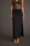 Full-length view of the black maxi skirt showing the drape and movement.
