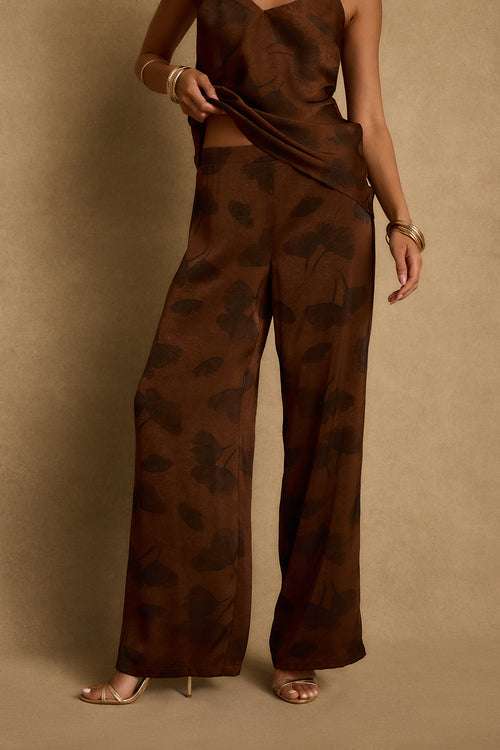 Espresso brown floral satin wide-leg pants worn with matching tank and gold heels.