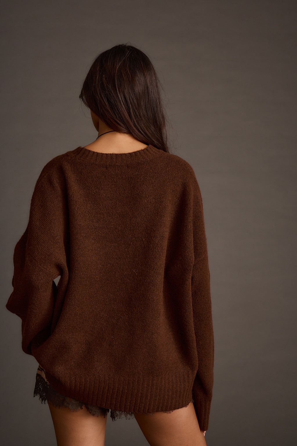 Back view of a brown oversized sweater with a relaxed drop-shoulder silhouette