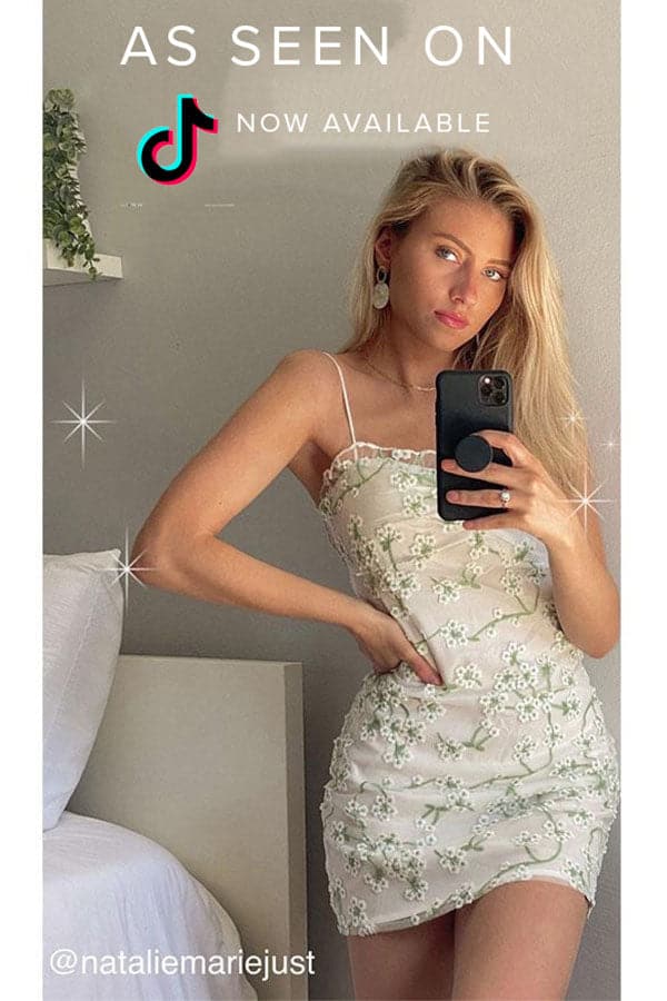 Lifestyle shot of the white mini dress styled for day-to-night versatility.